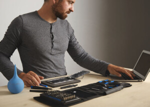 Mann repariert Laptop mit professionellen Werkzeugen